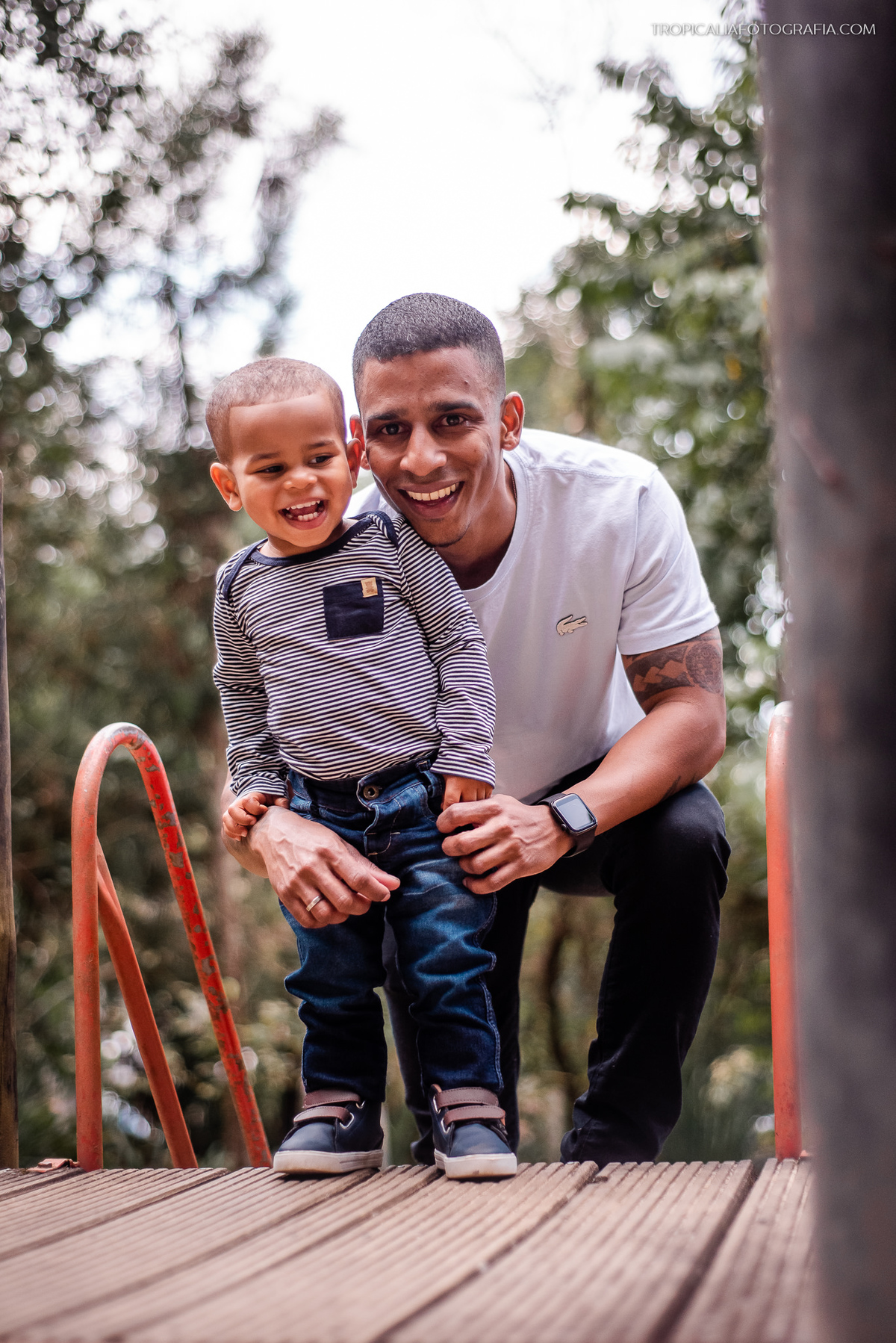 Ensaio documental de família em Nova Friburgo. Retrato do pai com o seu filho sorrindo
