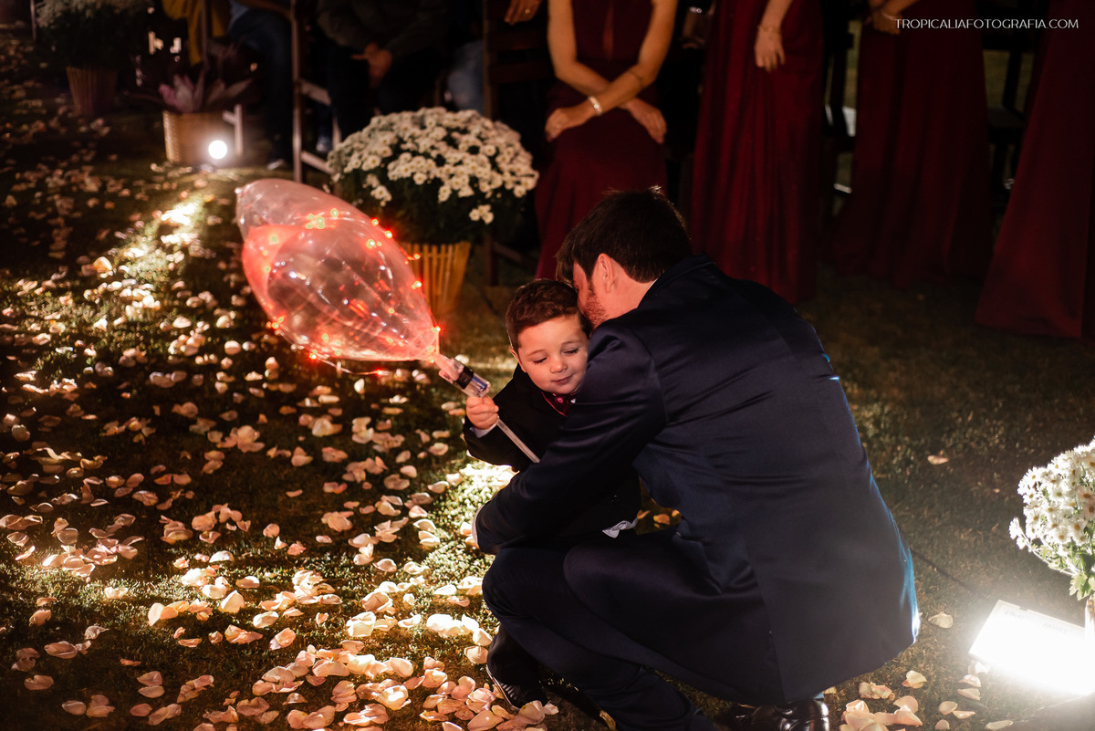 casamento em nova friburgo, regiao serrana do rio de janeiro. casa de festa fazenda natureza eventos decoração de sirlan. Foto do noivo abraçando o pajem