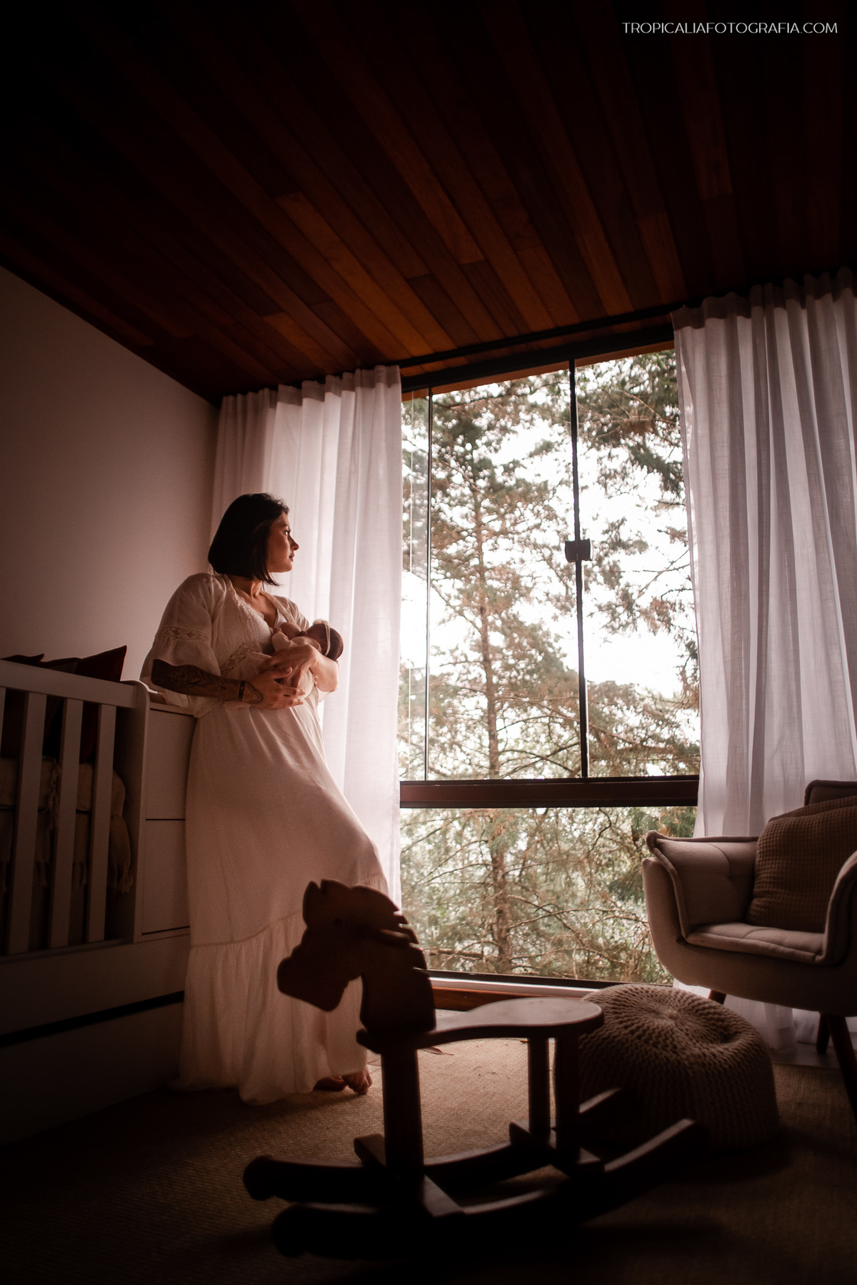 Ensaio documental de família em casa feito por fotógrafos em nova friburgo região serrana do rio de janeiro. Foto da mãe amamentando no quarto do bebê