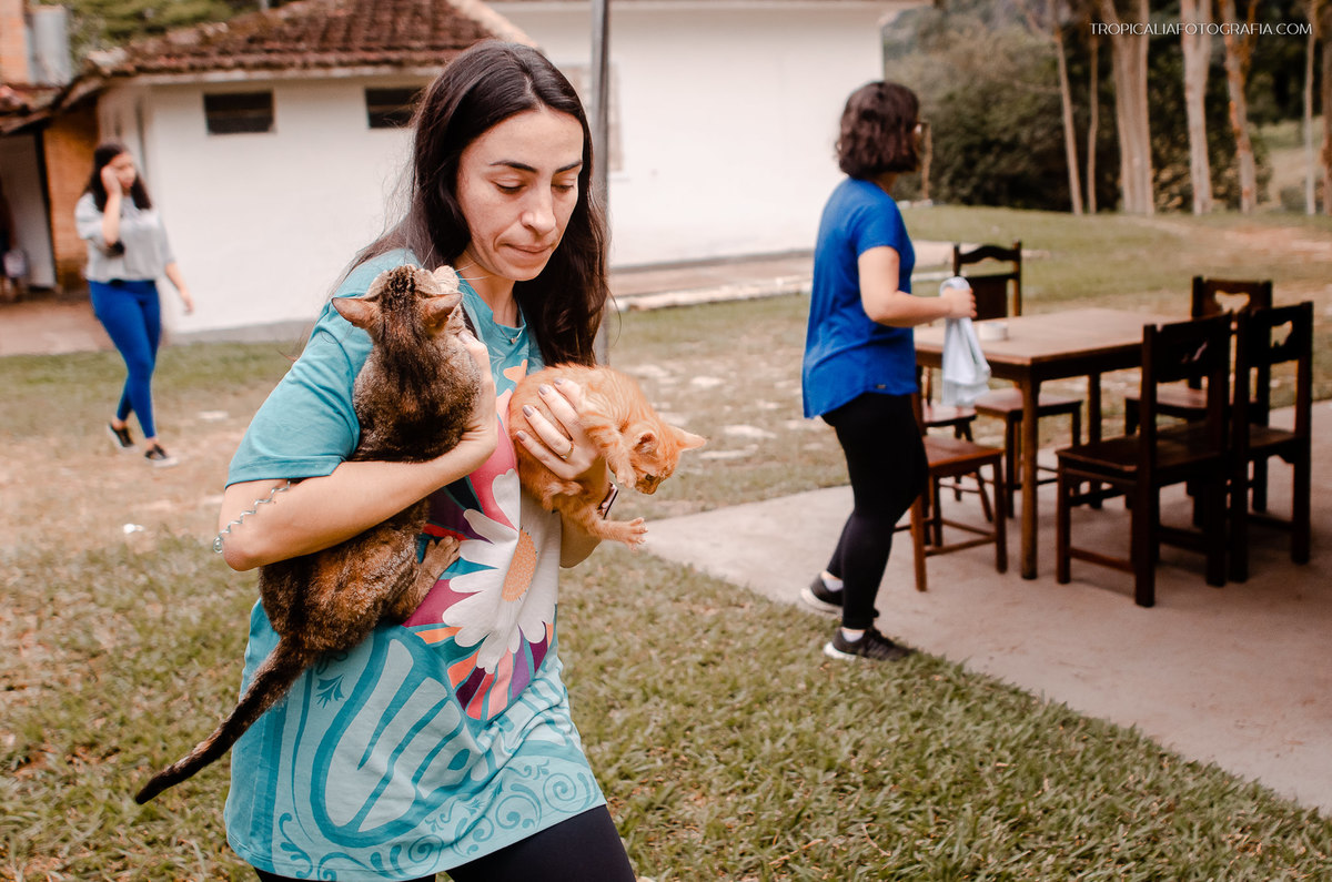 Fotógrafos de casamento em Nova Friburgo. Fotografia de casamento documental e foto jornalistica. Foto da convidada do casamento carregando dois gatos nos braços