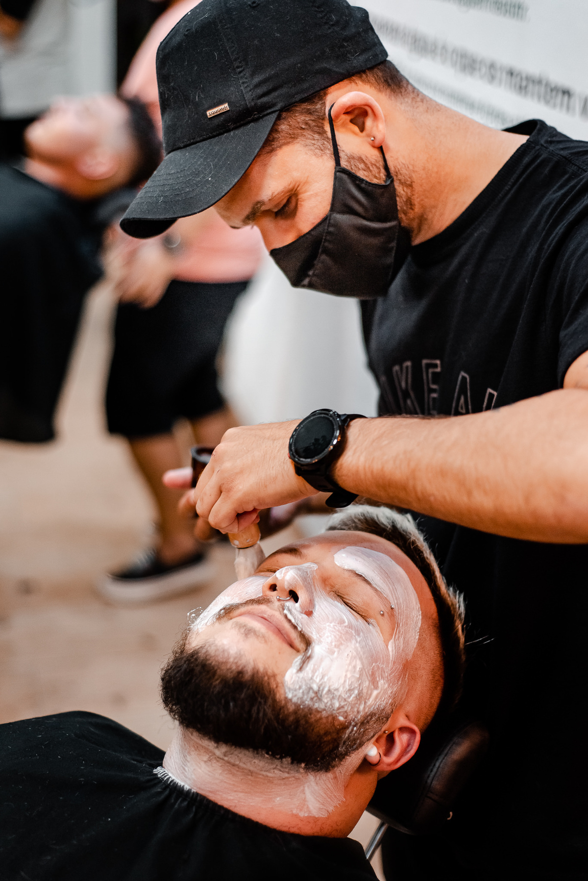 Foto do noivo sentado na cadeira da barbearia com uma máscara de argila no rosto durnte o making of do noivo. Fotógrafos de casamento em Nova Friburgo. Fotografia de casamento documental e foto jornalistica.