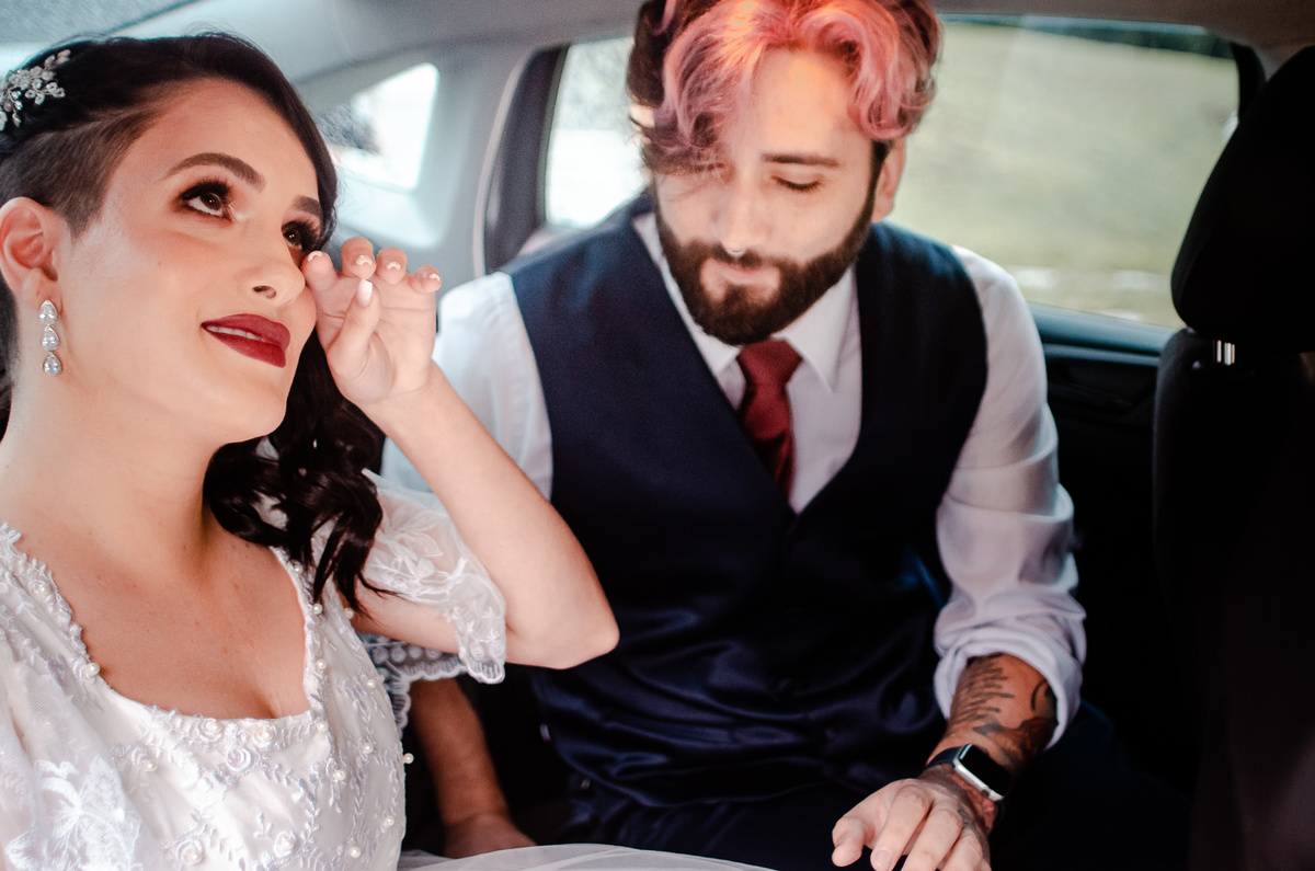 Foto da noiva limpando as lágrimas dentro do carro enquanto conversa com seu irmão antes da cerimônia do casamento. Fotógrafos de casamento em Nova Friburgo. Fotografia de casamento documental e foto jornalistica.