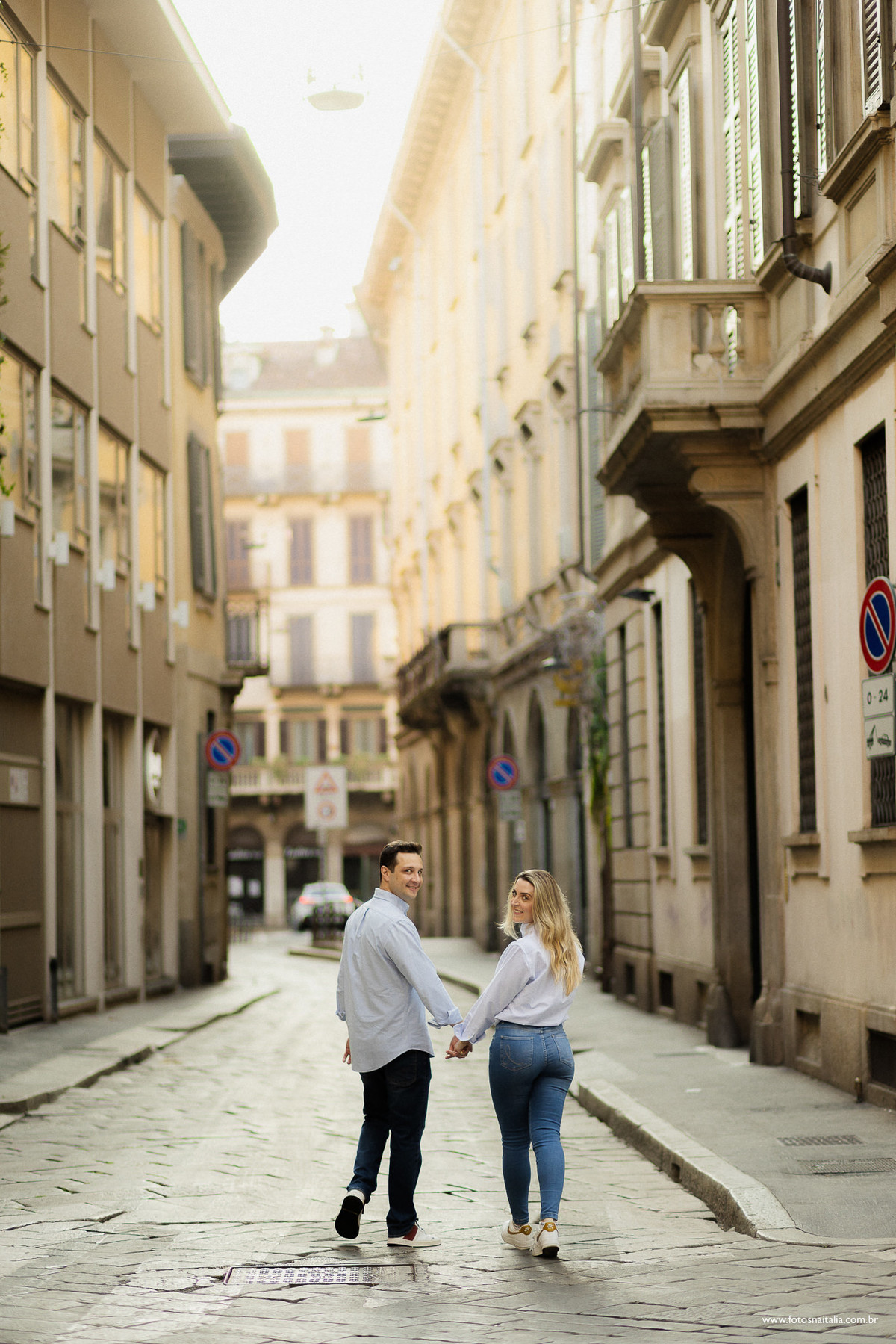 casal de costas caminhando por milão turistando pela cidade e olhando para trás