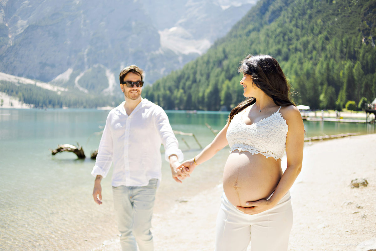 casal de branco fotos de gestante na itália nos aples montanhas lago di braies fotógrafo