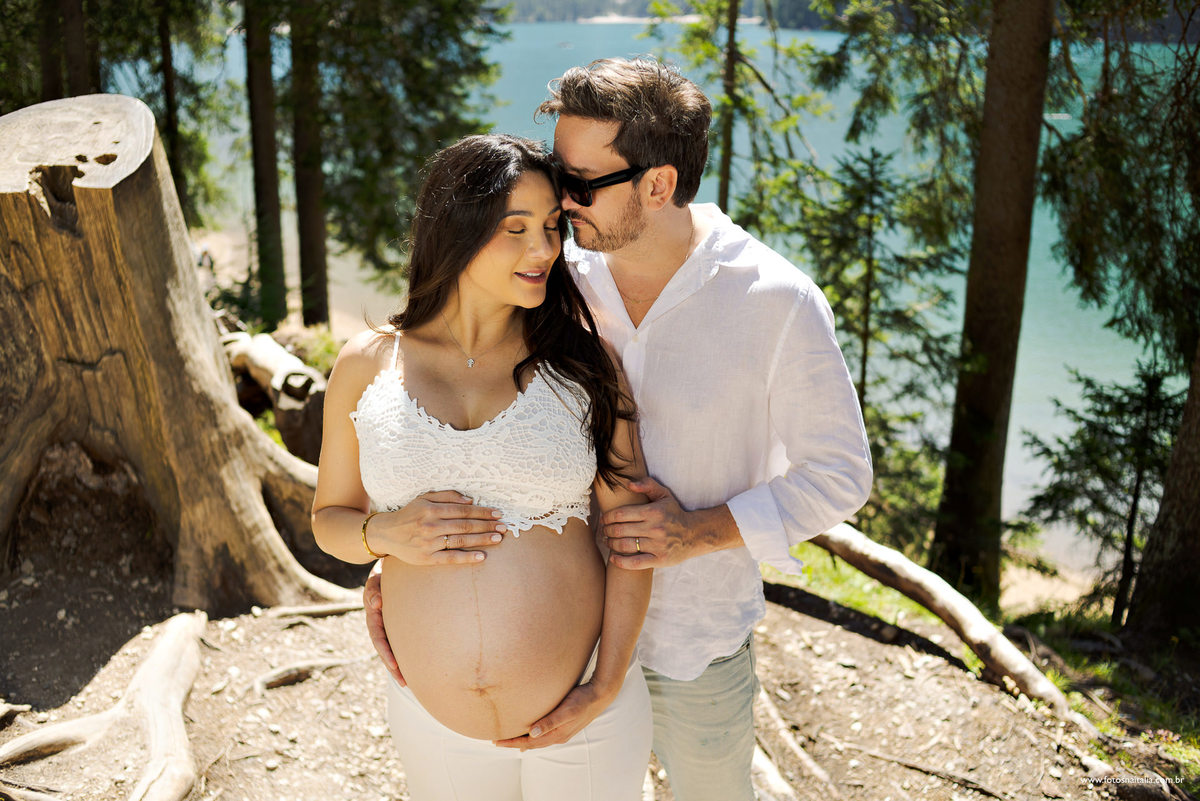 casal se beijando na natureza na Itália com lago das dolomitas ao fundo