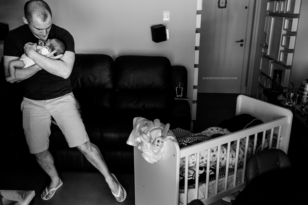 Papai embalando seu filho enquanto ele mama.