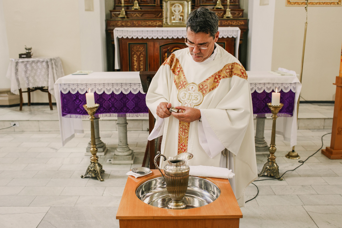 Padre Edson preparando a água benta para batizar as crianças na Igreja Matriz em São Leopoldo, RS.