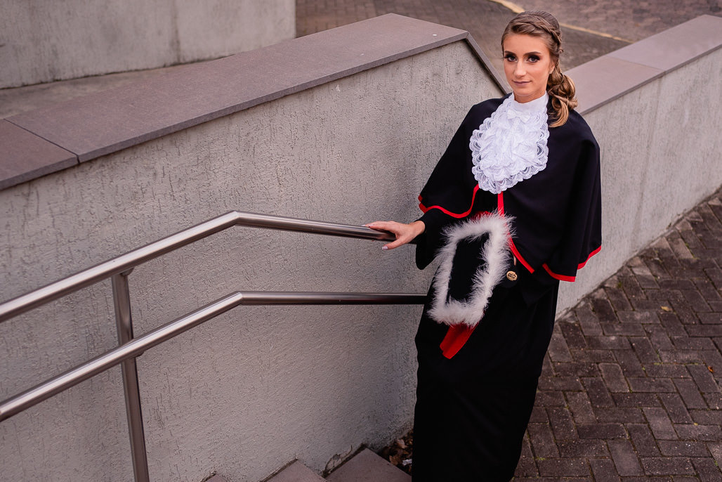 fotografia formatura ensaio prova de toga colação fiergs uniritter formanda direito golden hour fotógrafo porto alegre fotos feminina mulher loira olhos azuis vestido vermelho chapéu séria