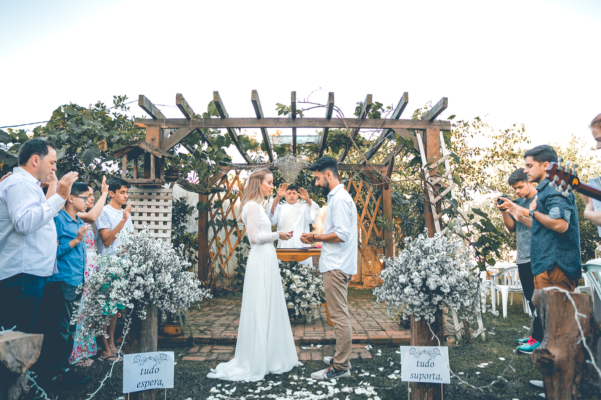 Família abençoando as alianças dos noivos. 
