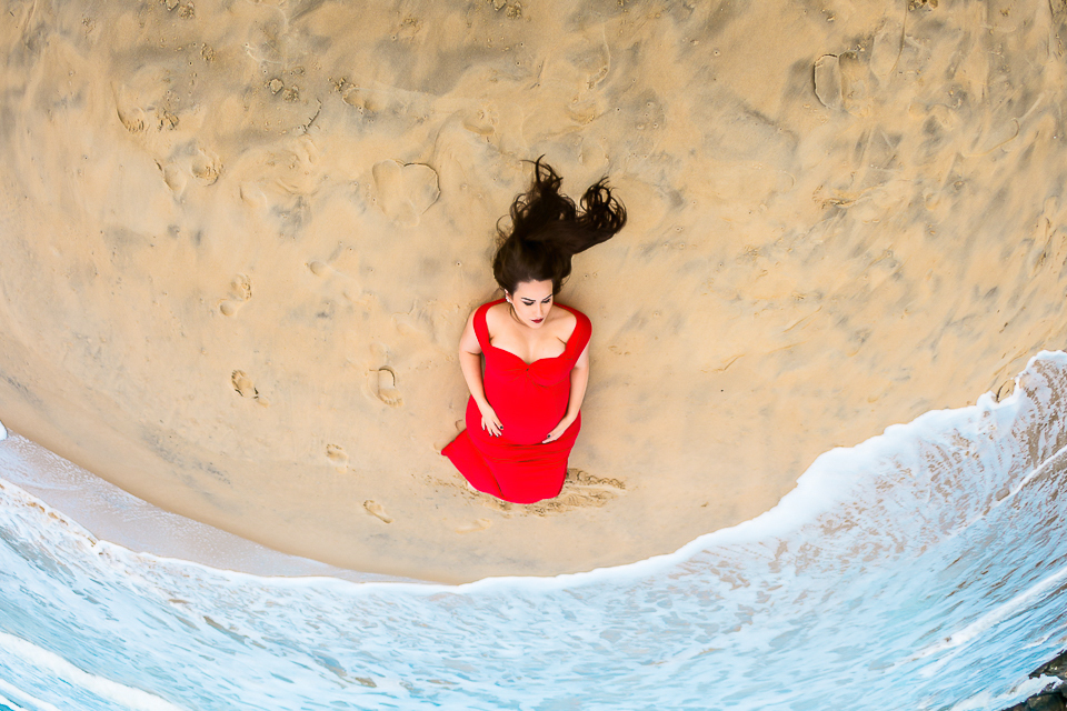 Gestante deitada na areia, na praia de cabeçudas