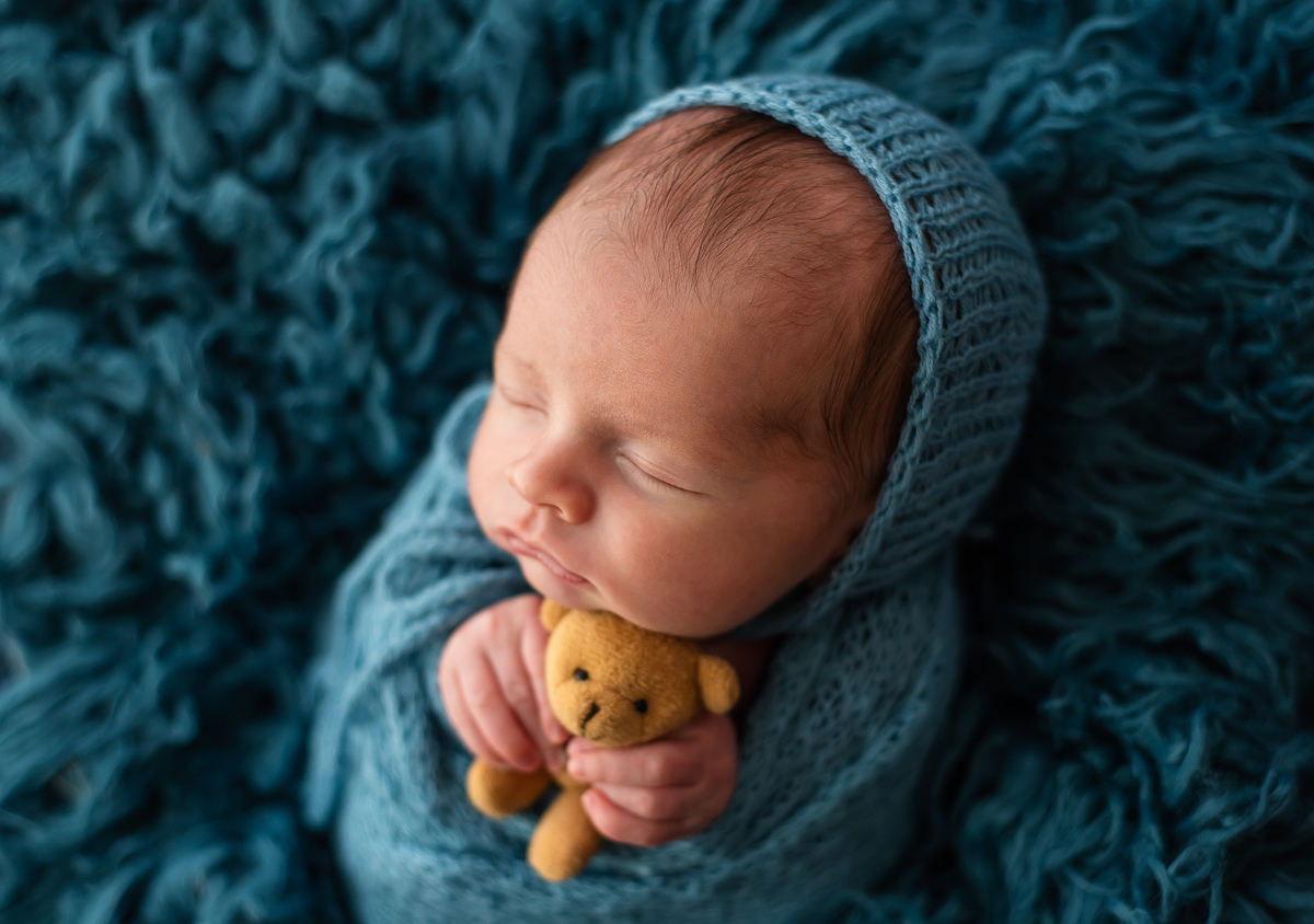 foto de bebê segurando ursinho