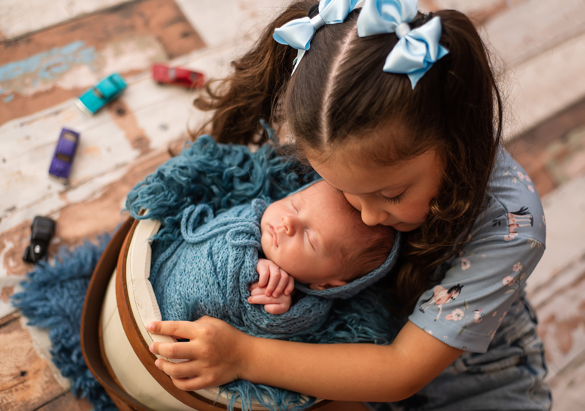 foto de menina abraçando bebê
