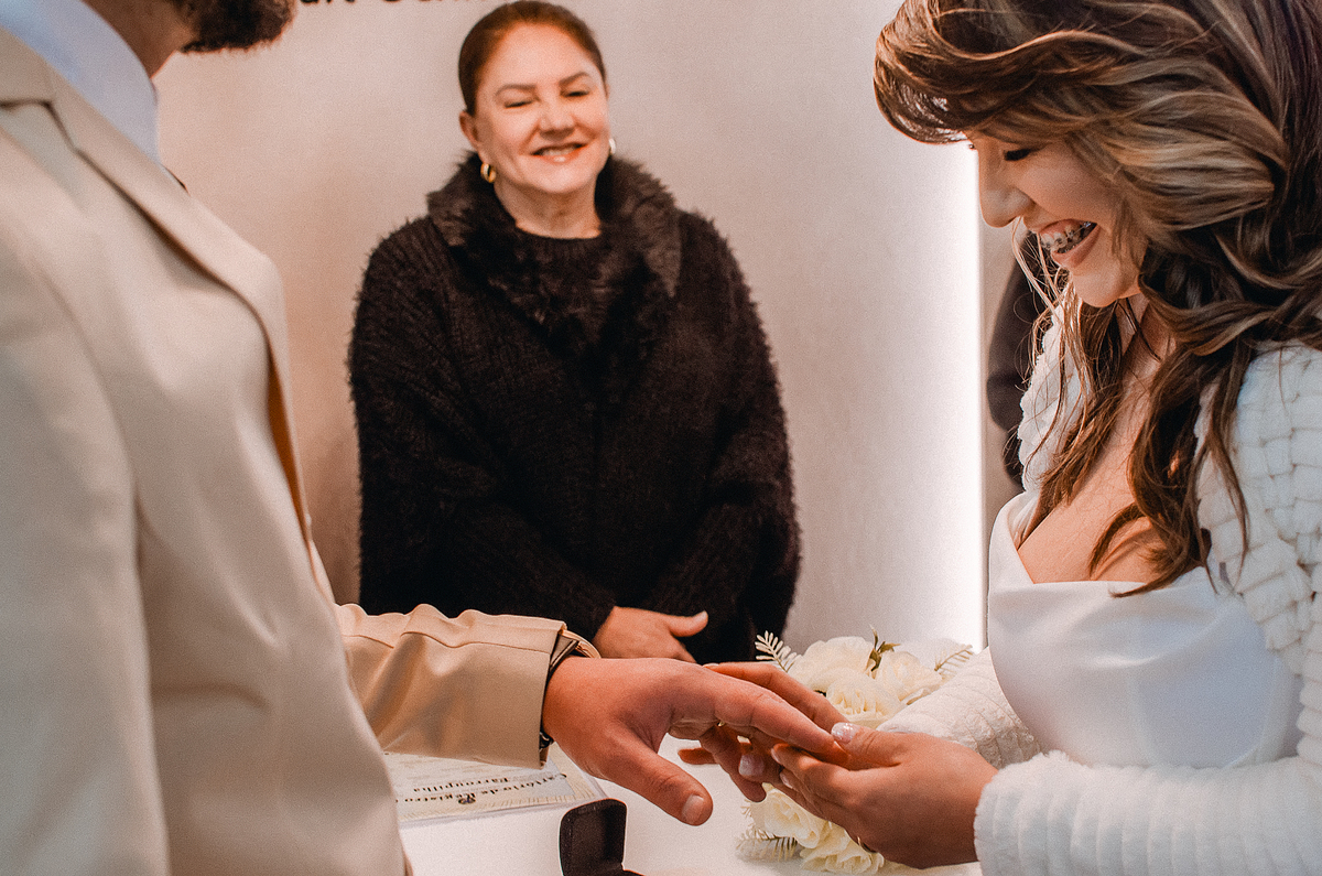 Noivos realizam a troca de alianças durante cerimônia de casamento civil, em um momento especial registrado em Farroupilha.