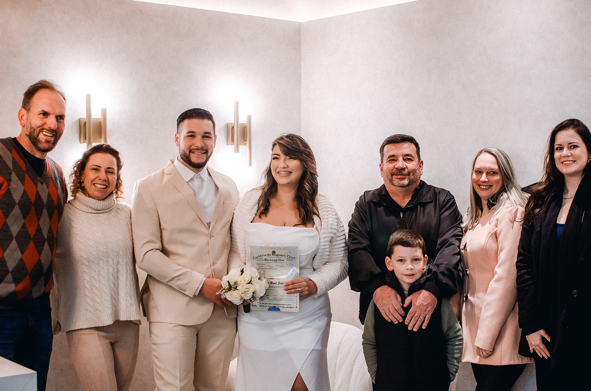Fotografia dos noivos com familiares e convidados após a celebração do casamento civil em Farroupilha, na Serra Gaúcha.