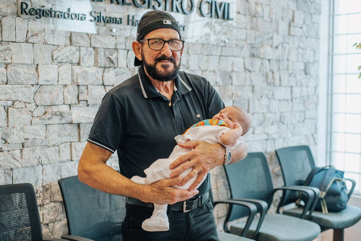 Convidado segura o bebê de Stefhanie e John durante o casamento civil em Farroupilha.
