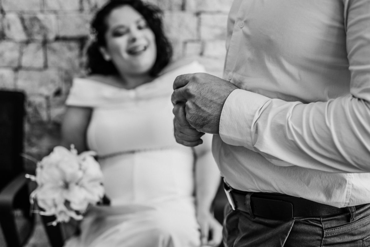 Fotografia em preto e branco de John acariciando o rosto de Stefhanie durante o casamento civil.