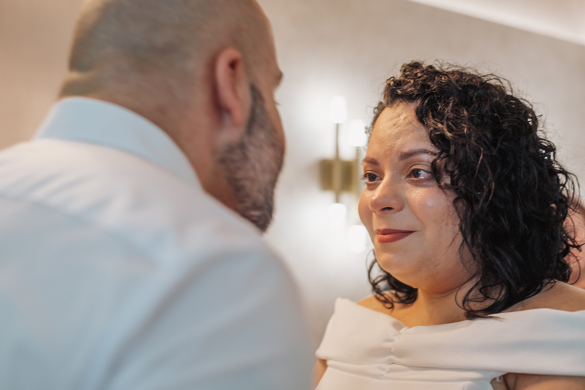 Stefhanie olha para John durante um momento de proximidade na cerimônia de casamento civil.