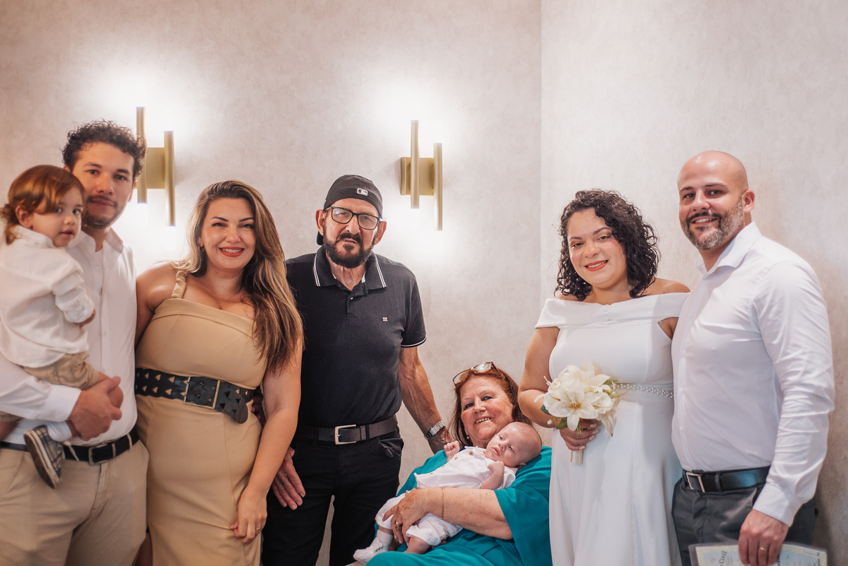 Stefhanie e John posam com familiares, padrinhos e o bebê do casal após o casamento civil em Farroupilha.