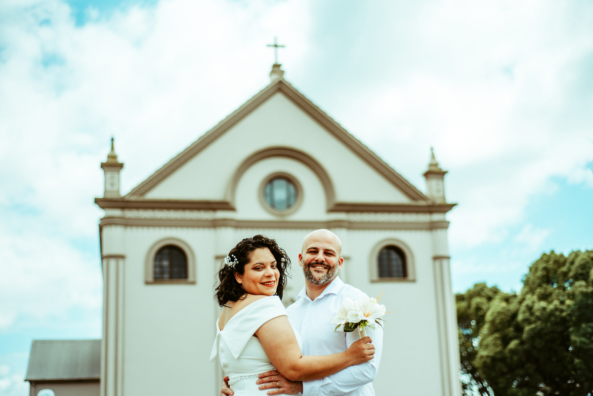 Stefhanie e John posam diante da fachada do Santuário de Nossa Senhora de Caravaggio em Farroupilha, RS.