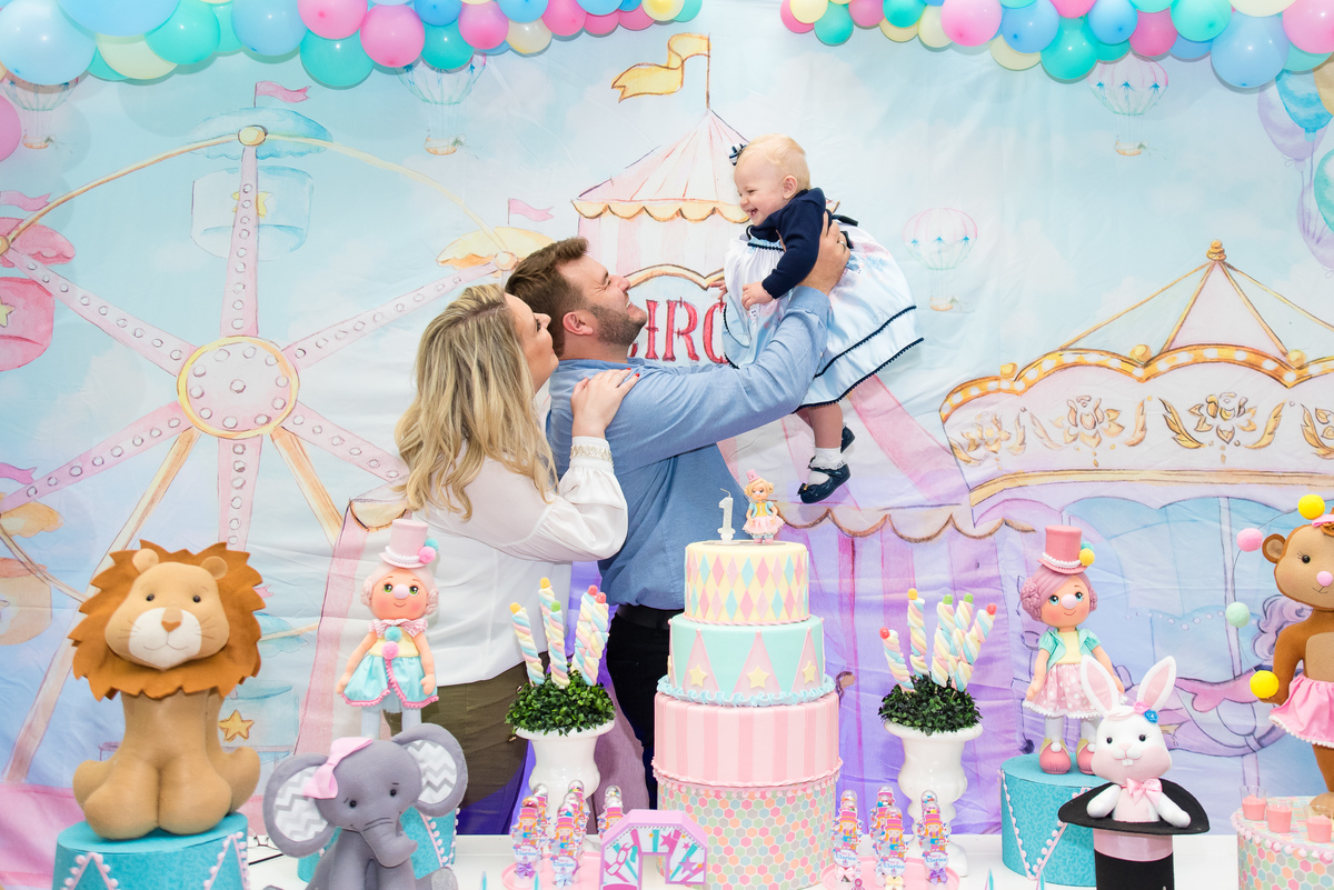 pais brincam com filha em aniversário infantil de um ano
