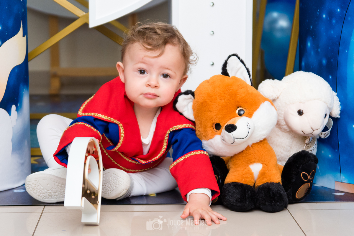 aniversariante brinca com a decoração de aniversário com tema pequeno príncipe