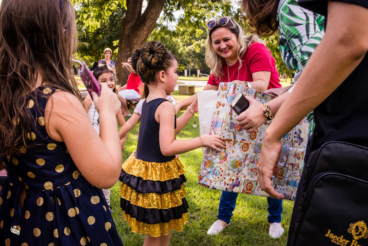A criança Teodora recebendo os presentes dos convidados