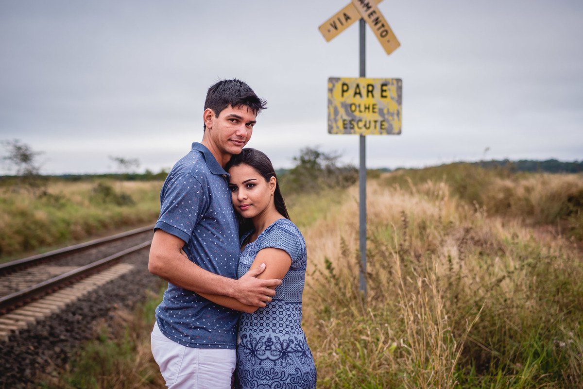 Foto de um ensaio do casal de noivos, Juliane e Fabio, se abraçando em meio a linha do trem em Rondonópolis-MT