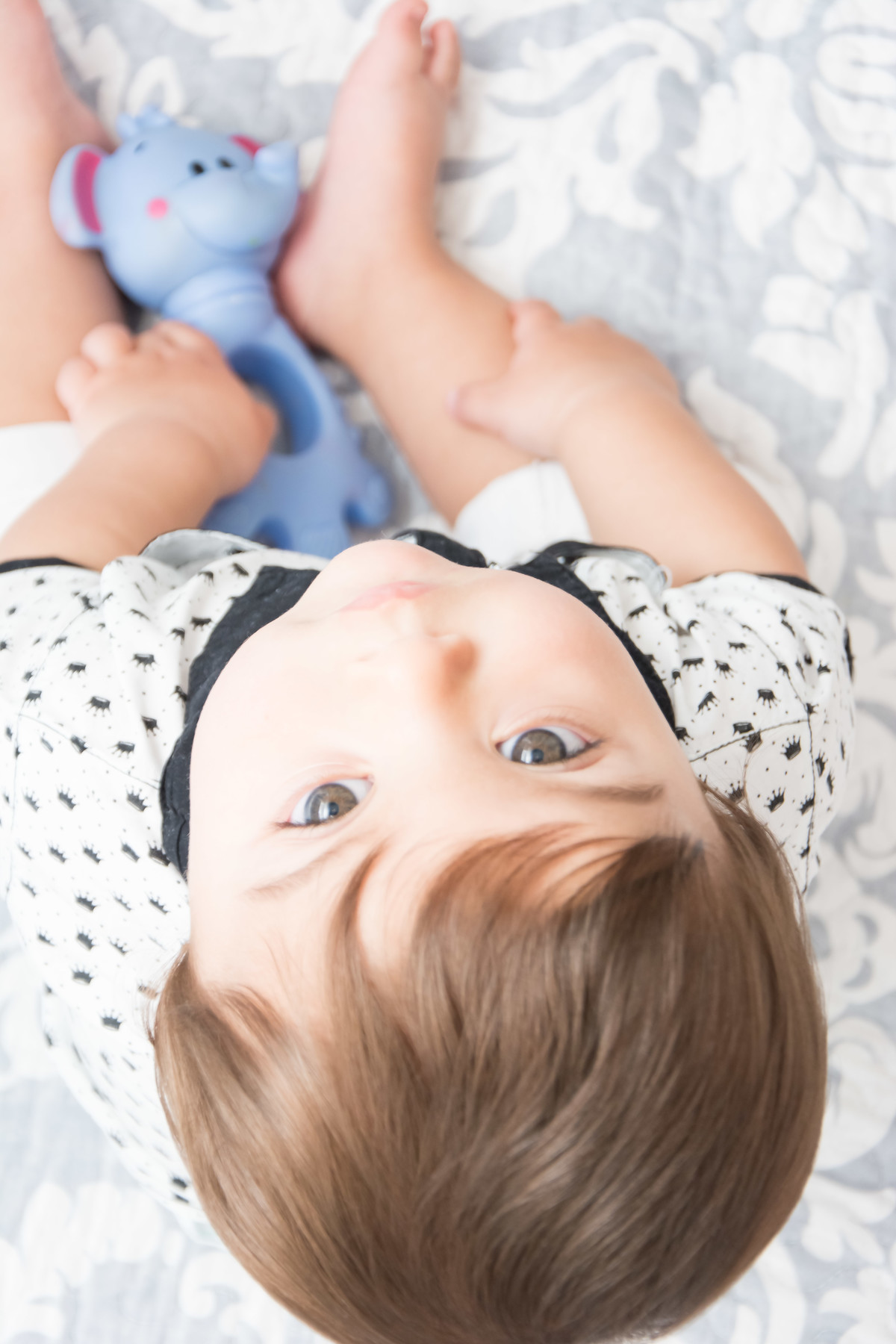 bebê olhando para cima com brinquedo