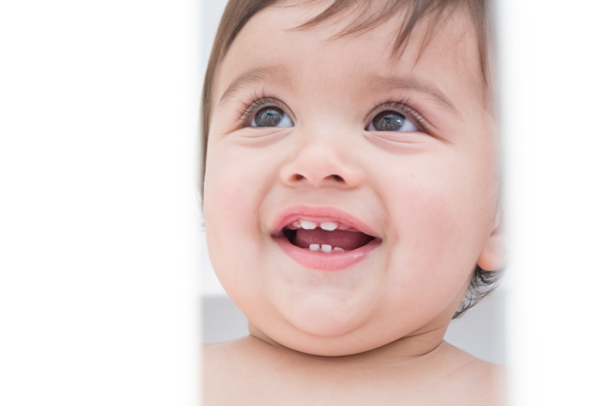 bebê sorrindo mostrando os dentinhos