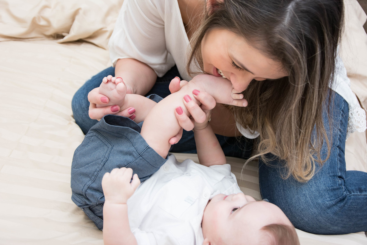 mamãe mordendo pézinho do bebê na cama