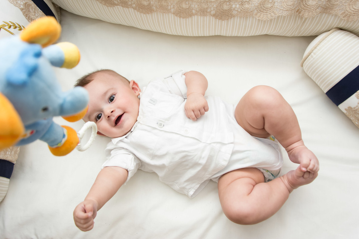 bebê de body branco no berço