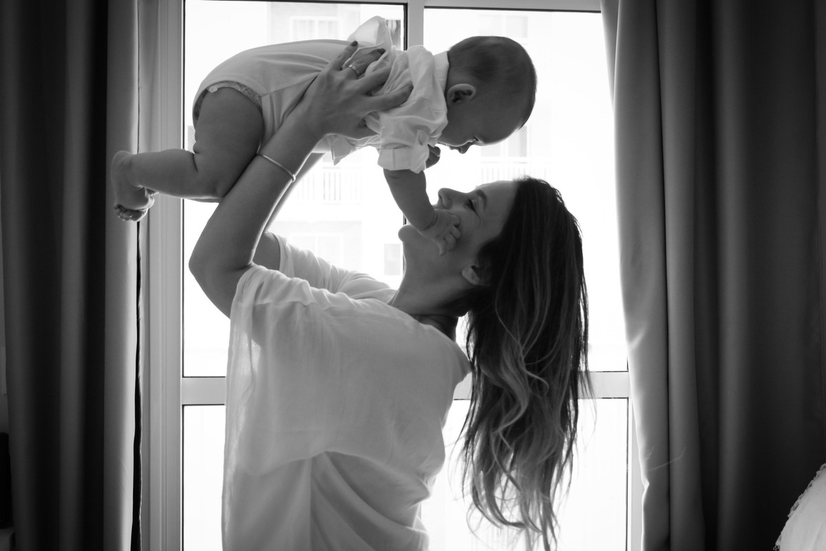 mamãe brincando com bebê na sala do apto