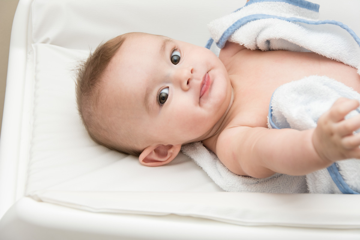 bebê fazendo caretinha no trocador depois do banho
