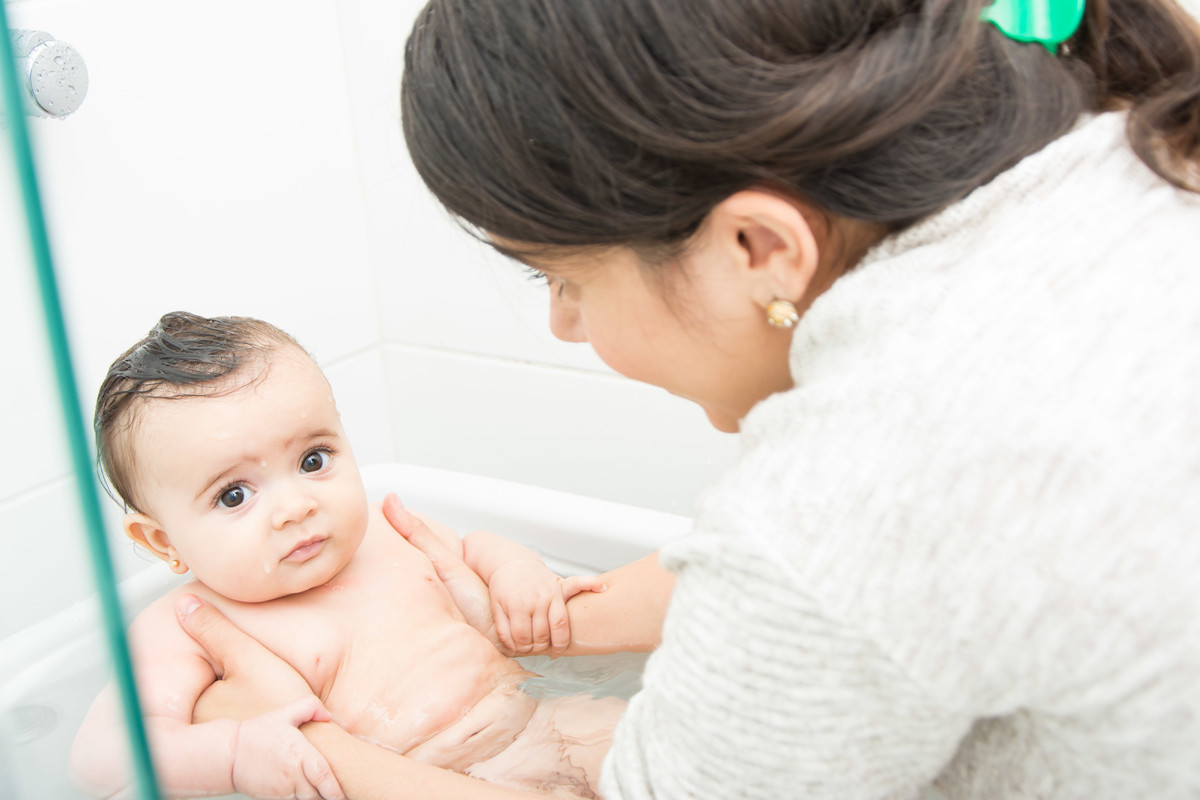bebê de olhos grandes tomando banho