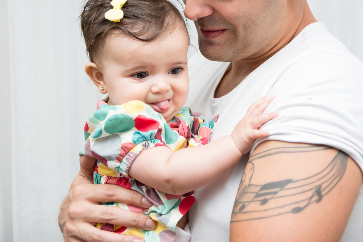 bebê de linguinha de fora no colo do papai
