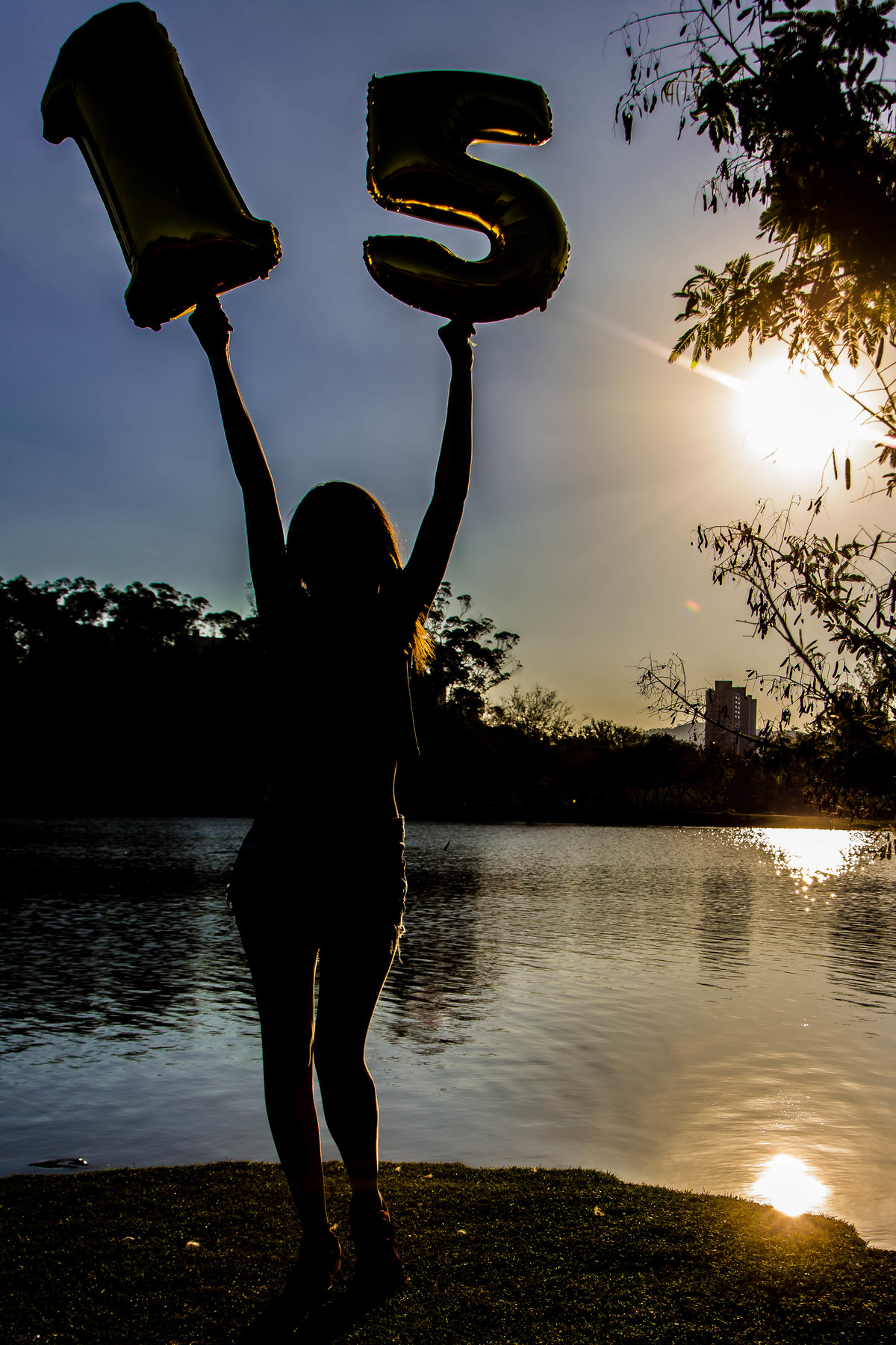 Ensaio debutante 15 anos em frente ao lago com balão metalizado