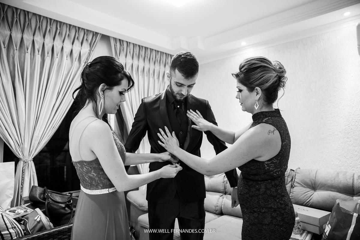 irmãs do noivo ajudando ele a se arrumar