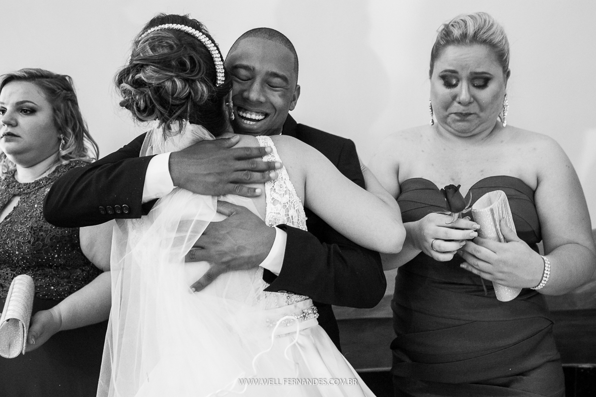 abraço alegre da noiva com o padrinho