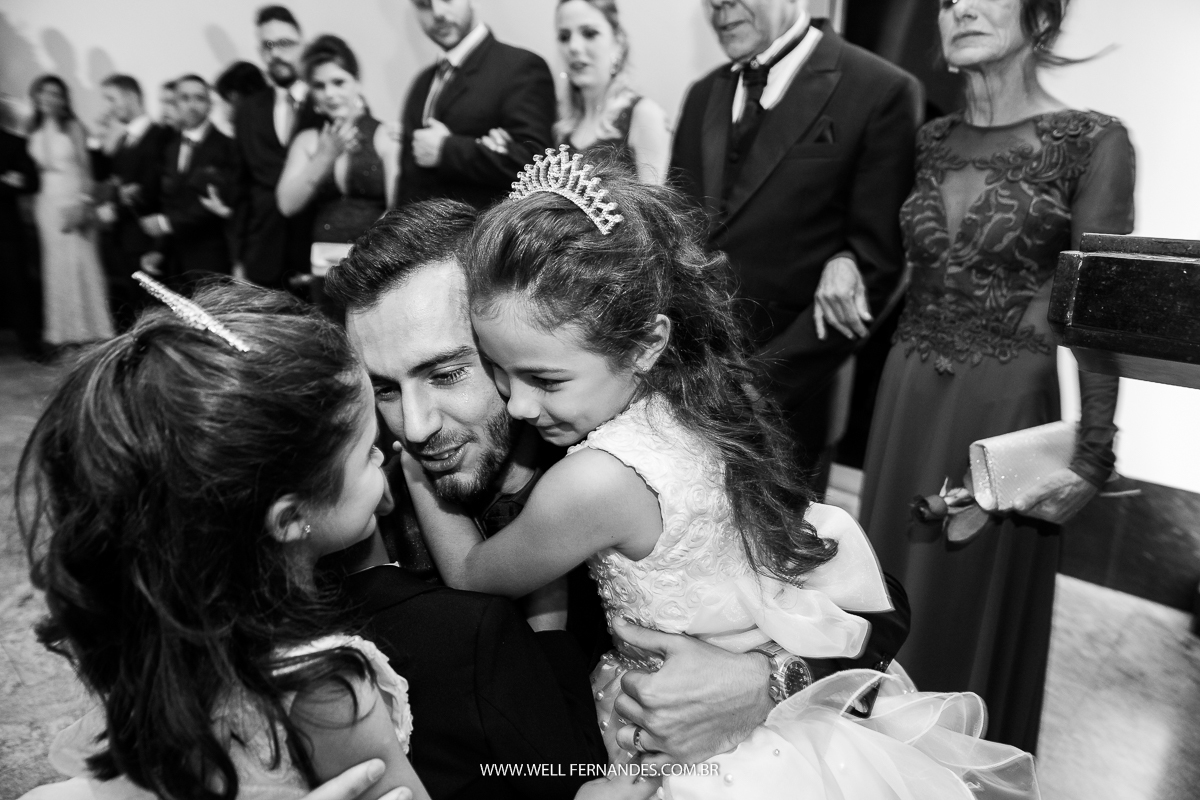 noivo abraçando as sobrinhas daminhas no altar da igreja