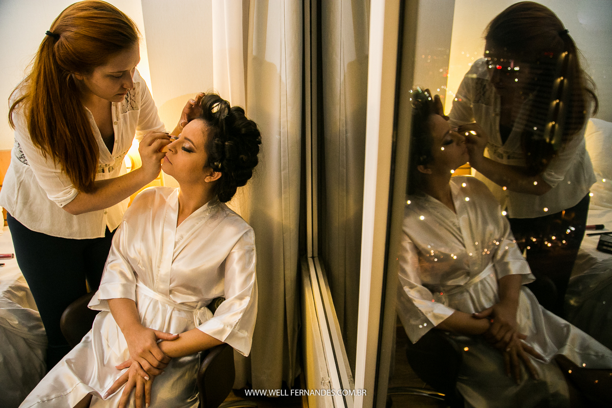 noiva se maquiando em frente a janela