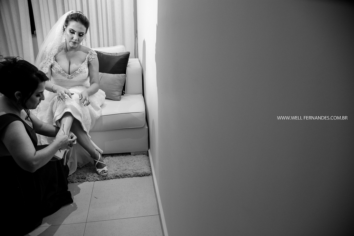 madrinha colocando o sapato na noiva