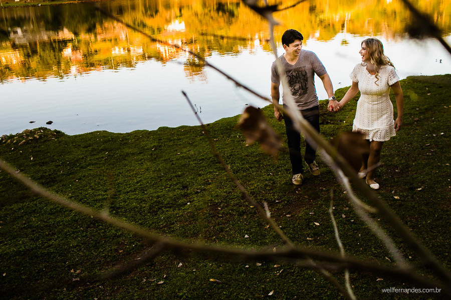 casal passeando de mão dadas em frente ao lago