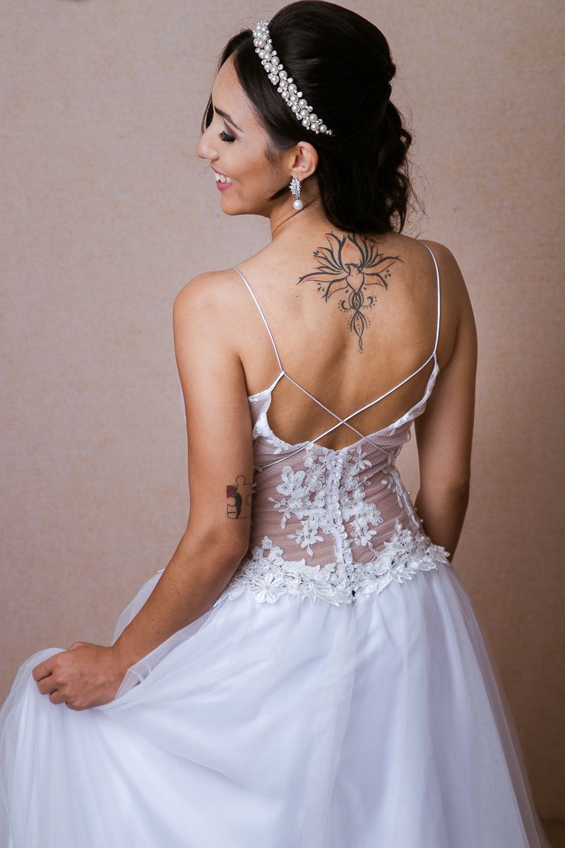 foto noiva com vestido e tatuagem nas costas