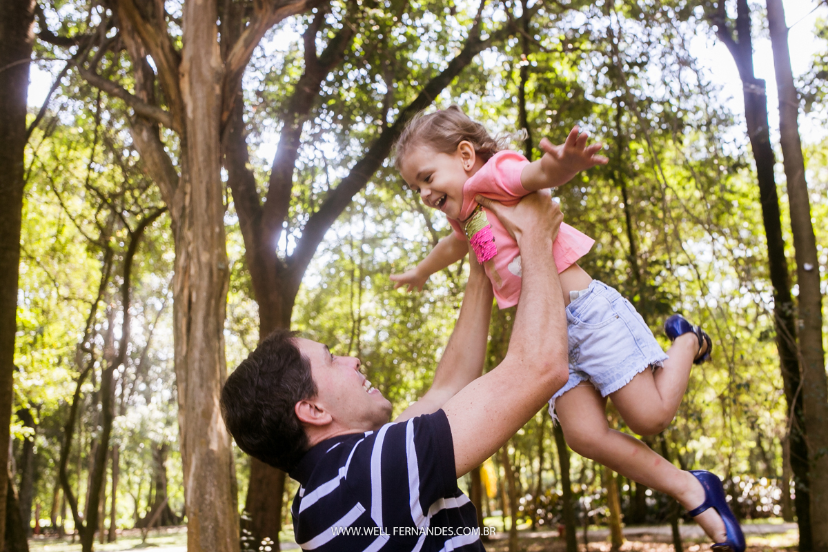 pai jogando a filha pro alto no parque ibirapuera