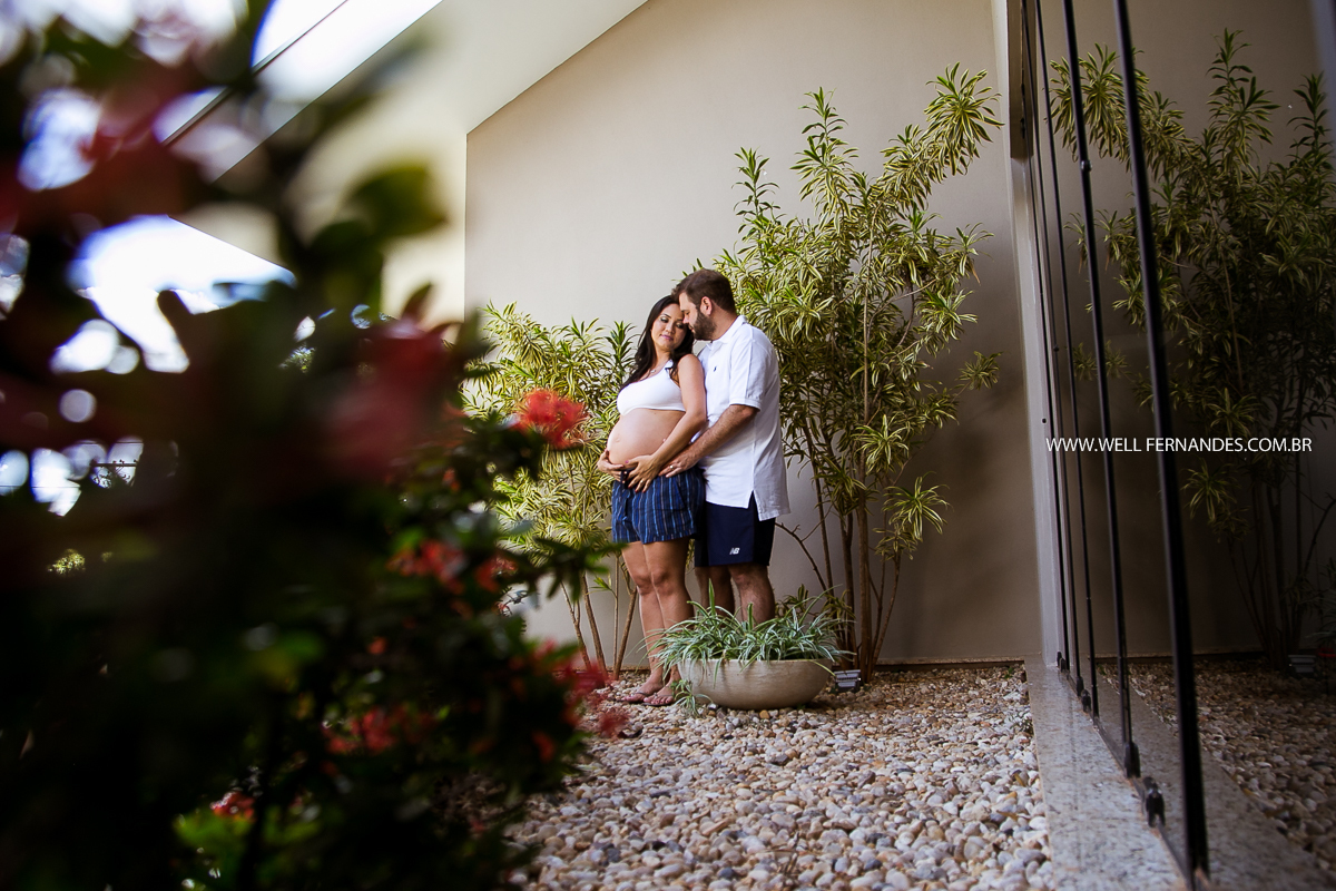 casal gestante posando para foto no jardim de casa