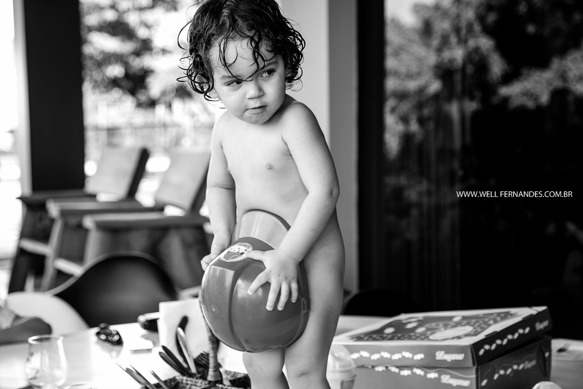 bebe brincando com capacete de combeiro em casa