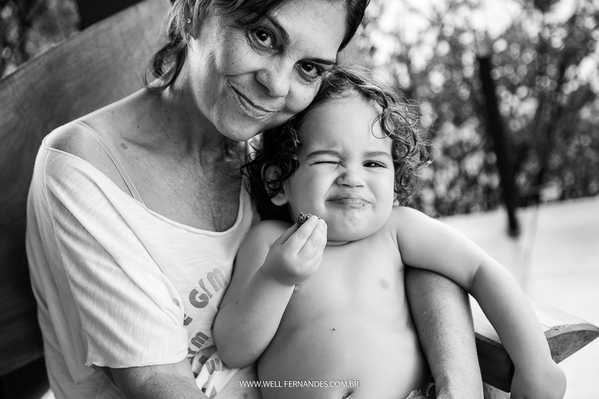bebe fazendo careta posando para a foto com a vo