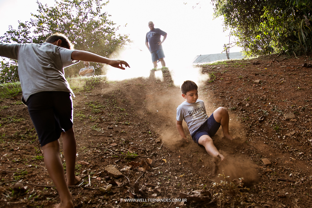 crianças escorregando no barranco de areia