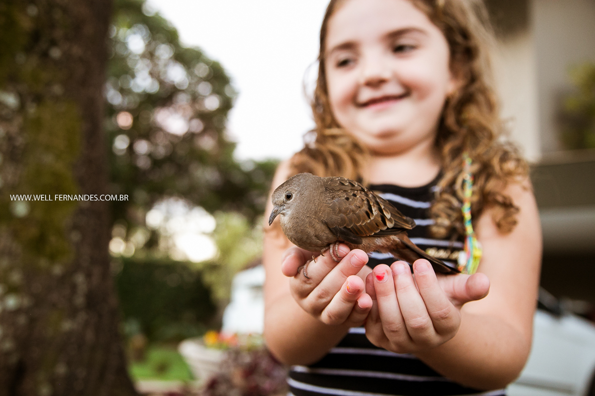 menina com passarinho na mão