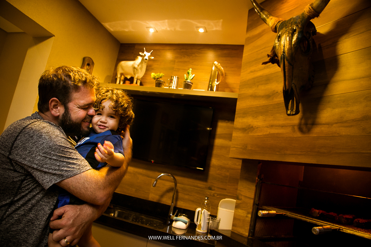 pai brincando com filho em frente a churrasqueira de casa